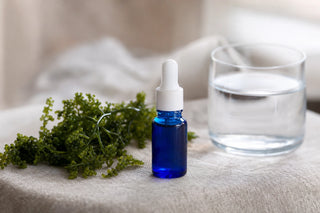 Flacon de phycocyanine liquide bleue et verre d'eau, ambiance sereine