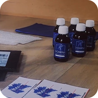 Bouteilles de phycocyanine Dohrnii prêtes à l’expédition avec enveloppes d'envoi sur une table.