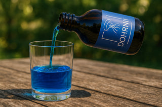 Phycocyanine liquide Dohrnii versée dans un verre, antioxydant naturel bleu issu de spiruline française.